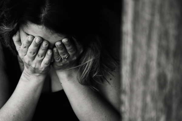 grief and pandemic sad woman with hands on her face