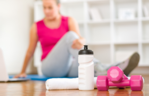 picture of dumbells, water bottle, and woman stretching