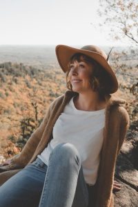 Photo by Clay Banks woman sitting on rock